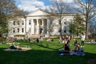 Students lay on blankets on the lawn in front of a building on American University’s campus in Washington, D.C.
