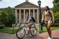 Students walking and riding bicycles on the campus of the University of North Carolina.
