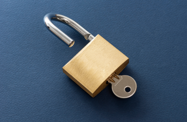 A key in an open padlock.