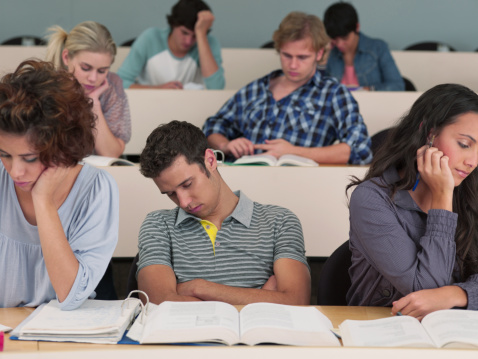 Stock image of student dozing off in class.