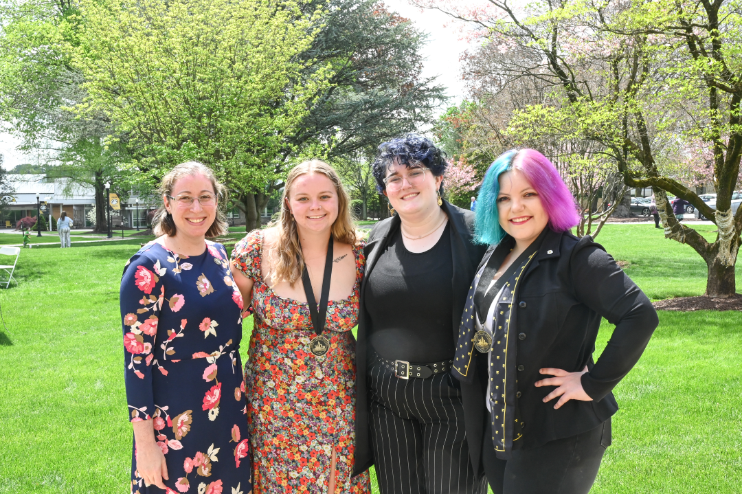 Cedar Crest College administrators, including one woman with blue and pink-purple hair, smile for a photo
