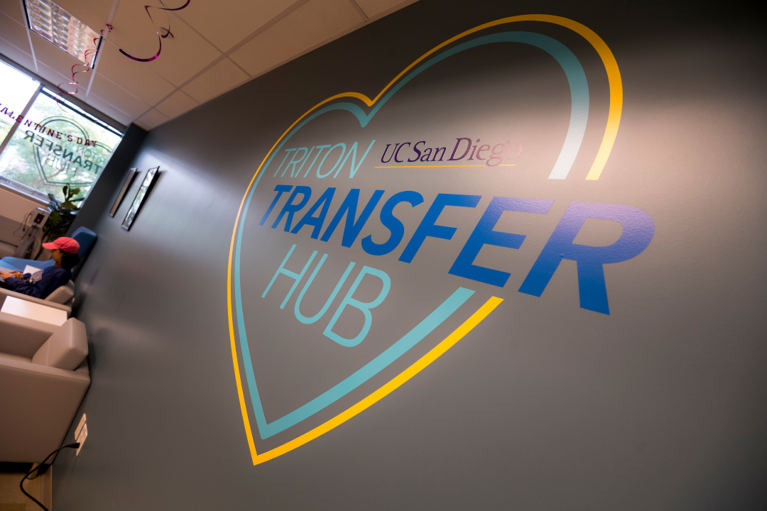 A mural on the wall of the Triton Transfer Hub is a heart with a blue and yellow outline with the hub’s name in the center.