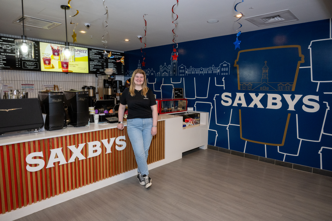 Chloe Knill smiles in the Saxbys cafe location in front of the counter