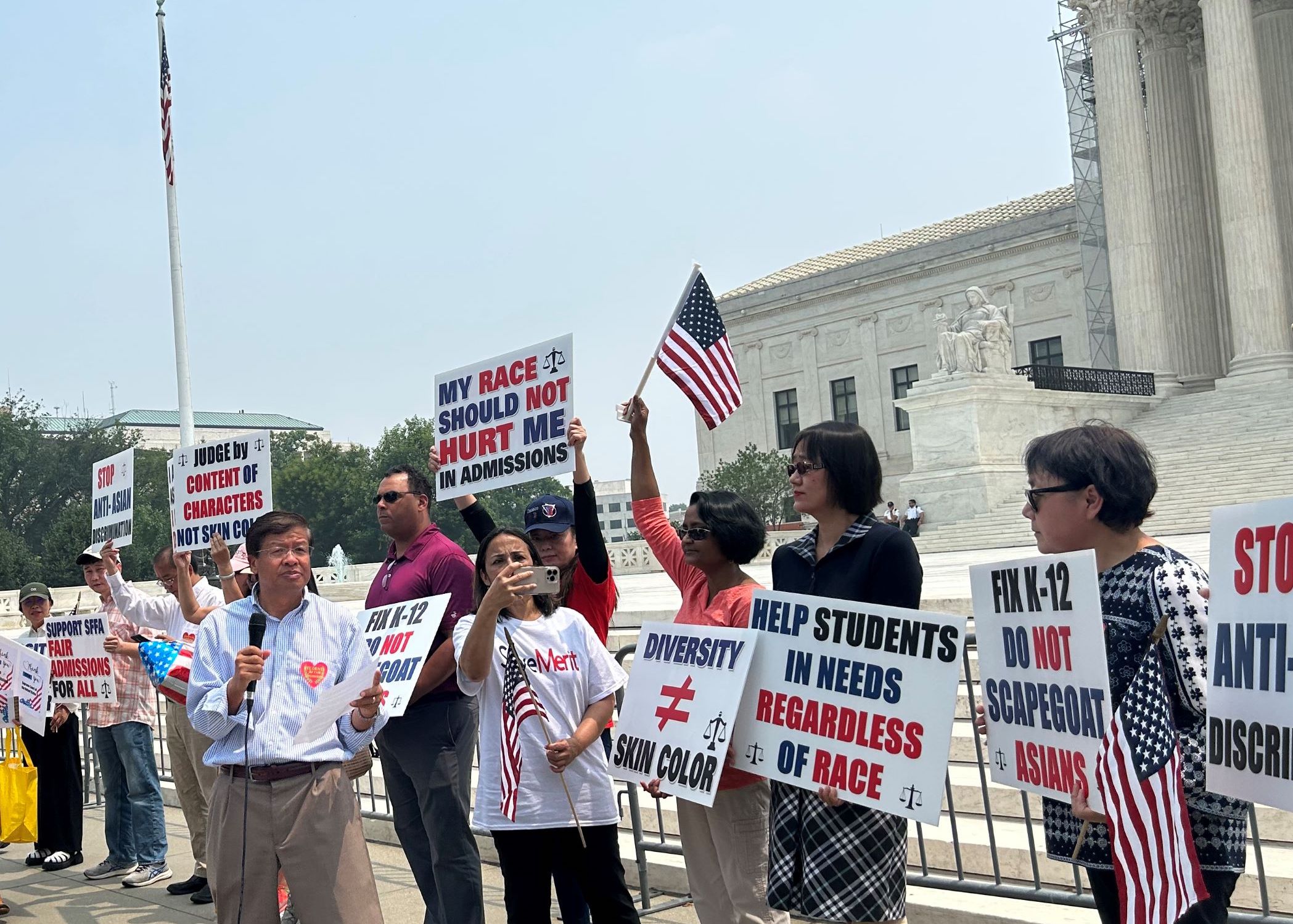 Demonstrators who support the Supreme Court's ruling on affirmative action hold signs during a rally in front of the Supreme Court.