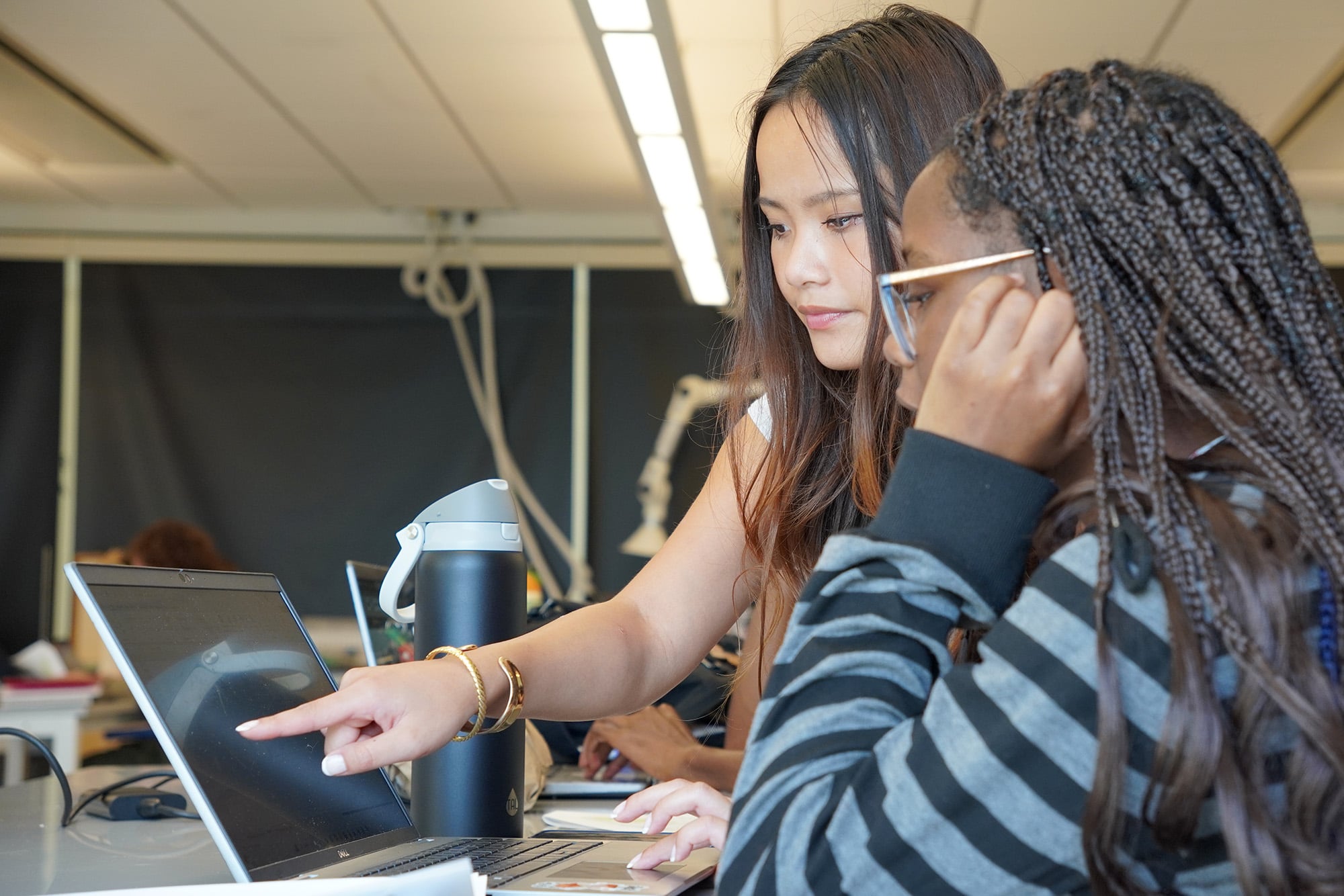 A photo of two students working at a computer.