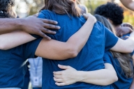 Students are shown hugging in a circle