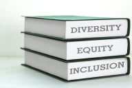 A stack of three books, stamped with the words "Diversity," "Equity" and "Inclusion."