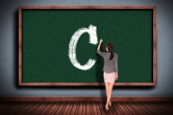Teacher writes a big C on a blackboard