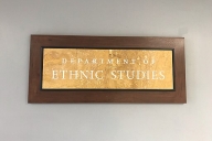 A gold plaque on a wooden background reads "Department of Ethnic Studies."