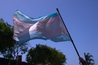 A blue and pink flag transgender pride flies in the wind.