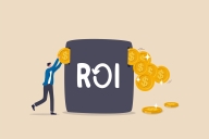 An illustration of a person inserting a gold coin into a black box labeled "ROI," with multiple coins coming out of the box's other side.