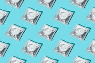 A pattern of silver condom wrappers on a blue background