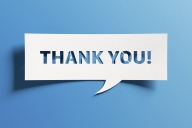 White text bubble–style sign on a blue background says, "Thank you!"