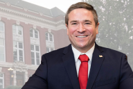 Andrew Bailey, a white man wearing a business suit and red tie