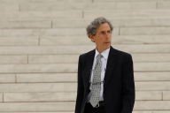 Edward Blum, a middle-aged light-skinned man with gray hair wearing a suit and standing on marble steps.