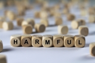 The word "harmful," spelled out in block letters, with one block per letter. Other blocks are strewn in the background.