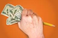 A closed fist holds $20 bills on one side and a pencil on the other. 