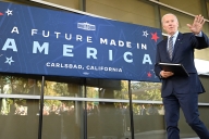 President Biden walks in front of a blue sign that says "Future Made in America."