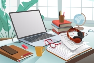 desktop with open computer, books, papers, eyeglasses and pen and pencil holder