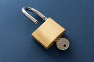 A key in an open padlock.