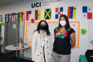 Two students wear masks in front of the UCI Latinx Resource Center.
