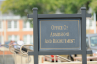 A large sign on a university campus that reads "Office of Admissions and Recruitment."