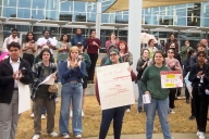 A photograph of protesting students holding signs on the University of Alabama at Birmingham's campus.