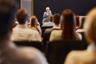 A lone professor in a crowded lecture hall