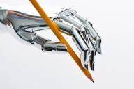 Robot hand holds pencil facing down as if about ready to draw