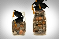 A quart and a pint jar filled with coins are side by side. Each jar has a mortar graduation cap on.