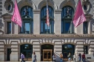 Students walk in front of a stone building that has School of the Art Institute of Chicago emblazoned across the front