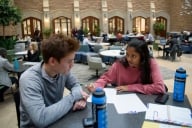 Evan Brown Ton, 19, middle, and Sejal Rajamani, right, go over homework in the main hall of the School of Law building at Washington University in St. Louis, MO.