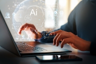 A close-up of a student’s hands on a laptop keyboard with icons relating to AI seeming to emanate from the computer.