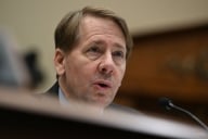 Richard Cordray speaks into a microphone at a hearing in May 2023.