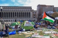 Pro-Palestinian protestors camp on the lawn outside Columbia University’s stately Butler Library this spring. Tents, sign and a Palestinian flag are all prominent in the photo.