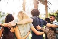 A group of friends embrace each other in a line