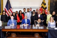 A photo of Maryland politicians, alongside Cameron Carden and his mother, Gay Green-Carden,at the signing of the Cameron Carden Act.