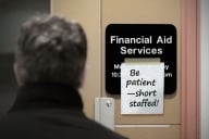 Back of a man’s head looking at a sign that reads “Be patient—short staffed.”