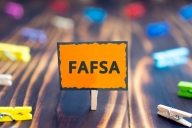 An orange sign with the word FAFSA in bold blacl letters. 