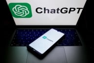 A computer screen and a smartphone both bear the logo and name of “ChatGPT” against a white background.