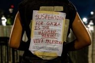 A photo of a protester at Columbia University wearing a sign reading “Suspension for Gaza is the Highest Honor! Viva Palestina.”