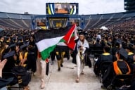 Pro-Palestinian protesters carrying a large Palestinian flag at the University of Michigan graduation