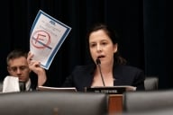Elise Stefanik holds up a white piece of paper with a red F in the middle.