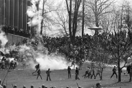 A black-and-white image of members of the National Guard firing tear gas at student protestors at Kent State University on May 4, 1970.