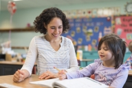 A teacher works with a student on a writing exercise