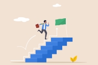 Young man with briefcase runs up six steps to green-flagged finish line