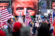 Large images of former president Trump's face on video screens loomed over a crowd of his supporters, many bearing American flags, as they gathered at the White House on Jan. 6, 2021.