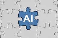 A blue jigsaw puzzle piece with the letters "AI" sits in the center of a puzzle; all the other pieces are white and blank.