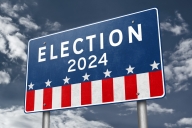 A red, white and blue highway billboard sign that says "Election 2024" above stars and stripes.