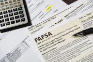 Close-up of federal financial aid application with calculator and tuition statement